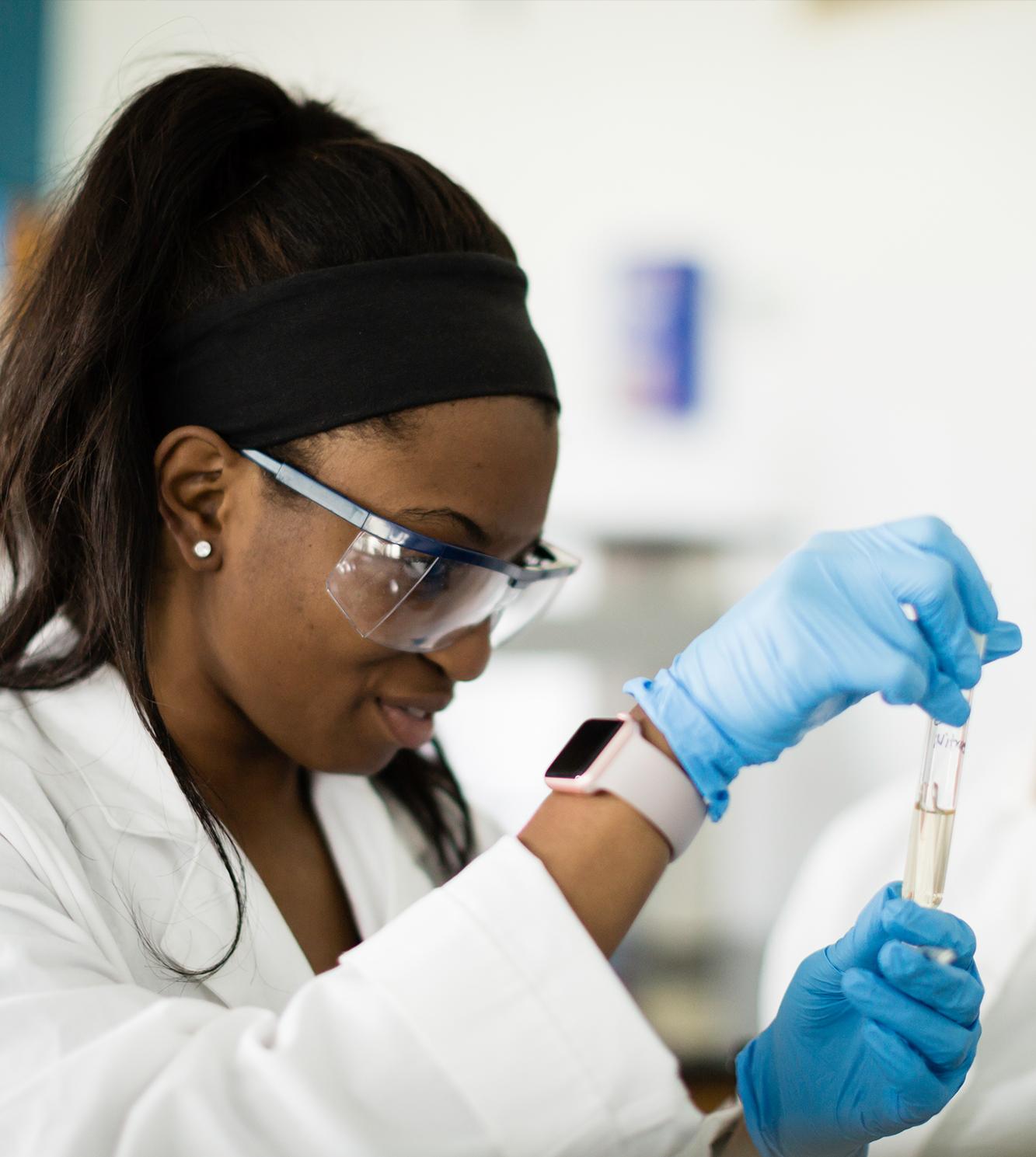 Photo of student in chemistry class with a test tube. 